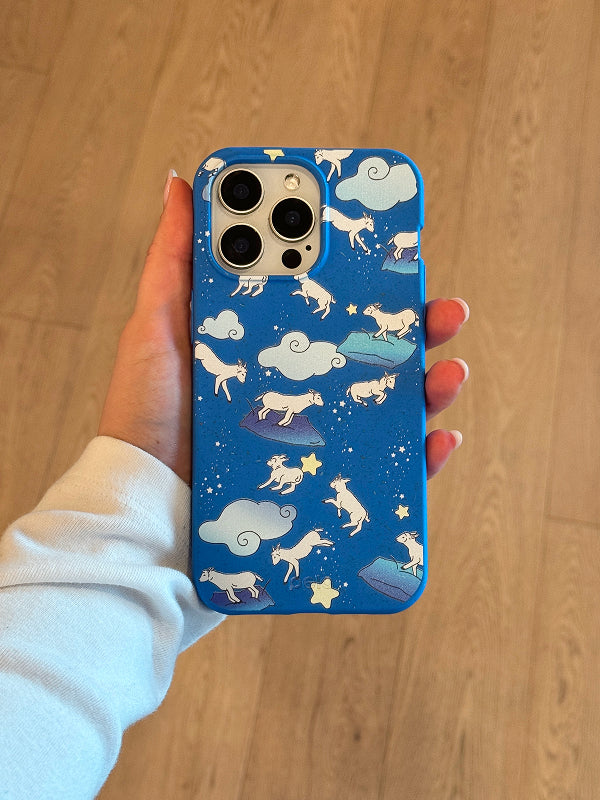Pela Electric Blue Sheep Dreamers Phone Case in hand showing design with jumping sheep, clouds, and stars.